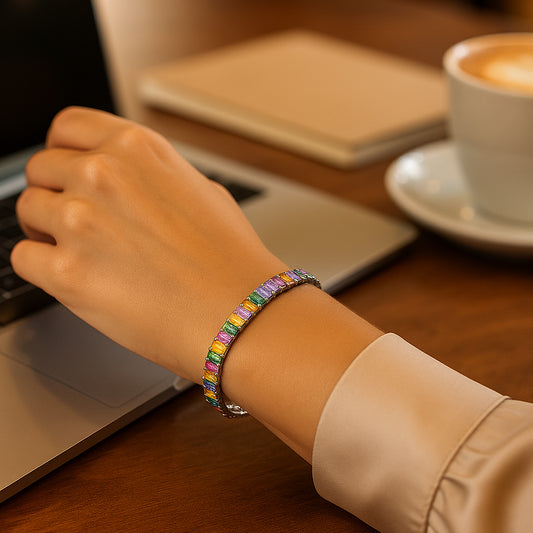 Stylisches Damenarmband aus 925er Silber mit bunten rechteckigen Zirkonia-Steinen - elegantes Regenbogen-Tennisarmband, getragen am Handgelenk, ideal für Alltag und Büro-Look.