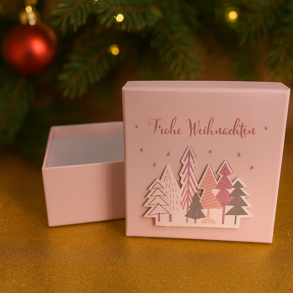 Rosa Schmuckverpackung mit Weihnachtsmotiv und Aufschrift „Frohe Weihnachten" - elegante Geschenkbox aus Karton mit Tannenbaum-Design für festliche Anlässe.