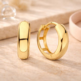 Breite, glänzende Creolen Ohrringe aus 585er Gold für Damen in schlichtem Design.