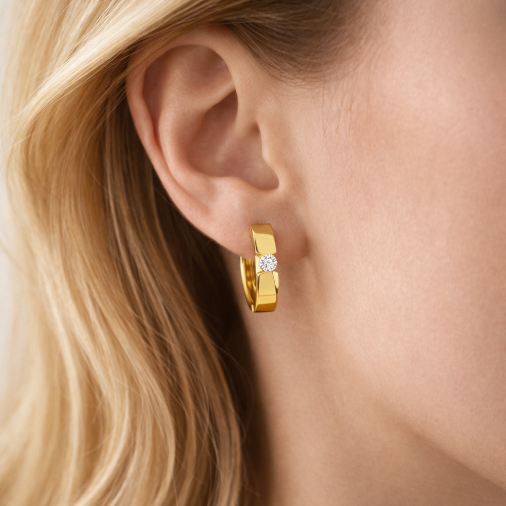 Creolen Ohrringe aus 585er Gold mit einzeln gefasstem Zirkonia-Stein, getragen am Ohr.