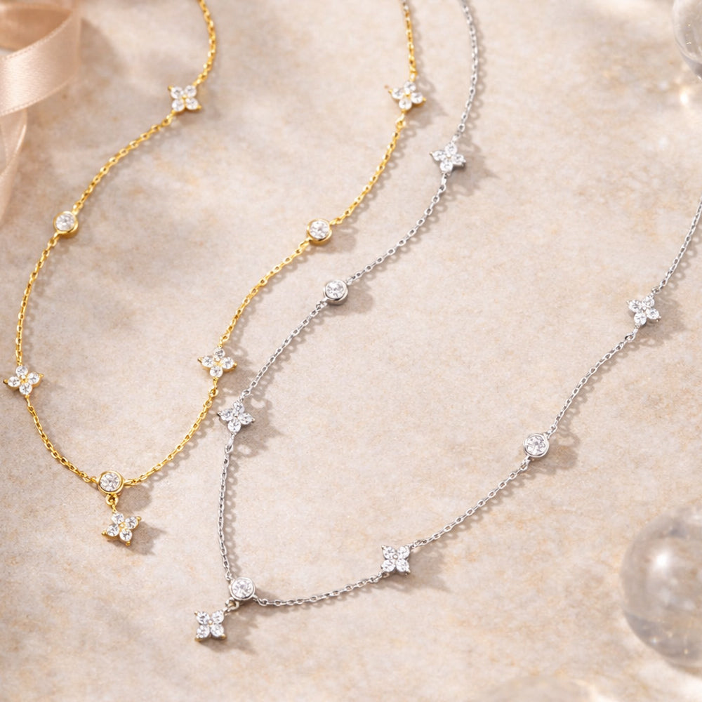 Elegante Halsskette aus 925 Sterling Silber mit glänzenden Steinen in Kleeblattdesign, filigrane Damenkette in Silber und Gold.