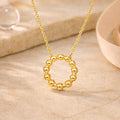 Goldene Halskette mit rundem Perlenkreis-Anhänger im minimalistischen Design.