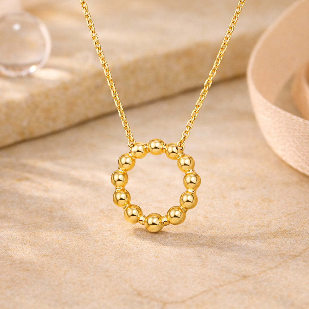 Goldene Halskette mit rundem Perlenkreis-Anhänger im minimalistischen Design.