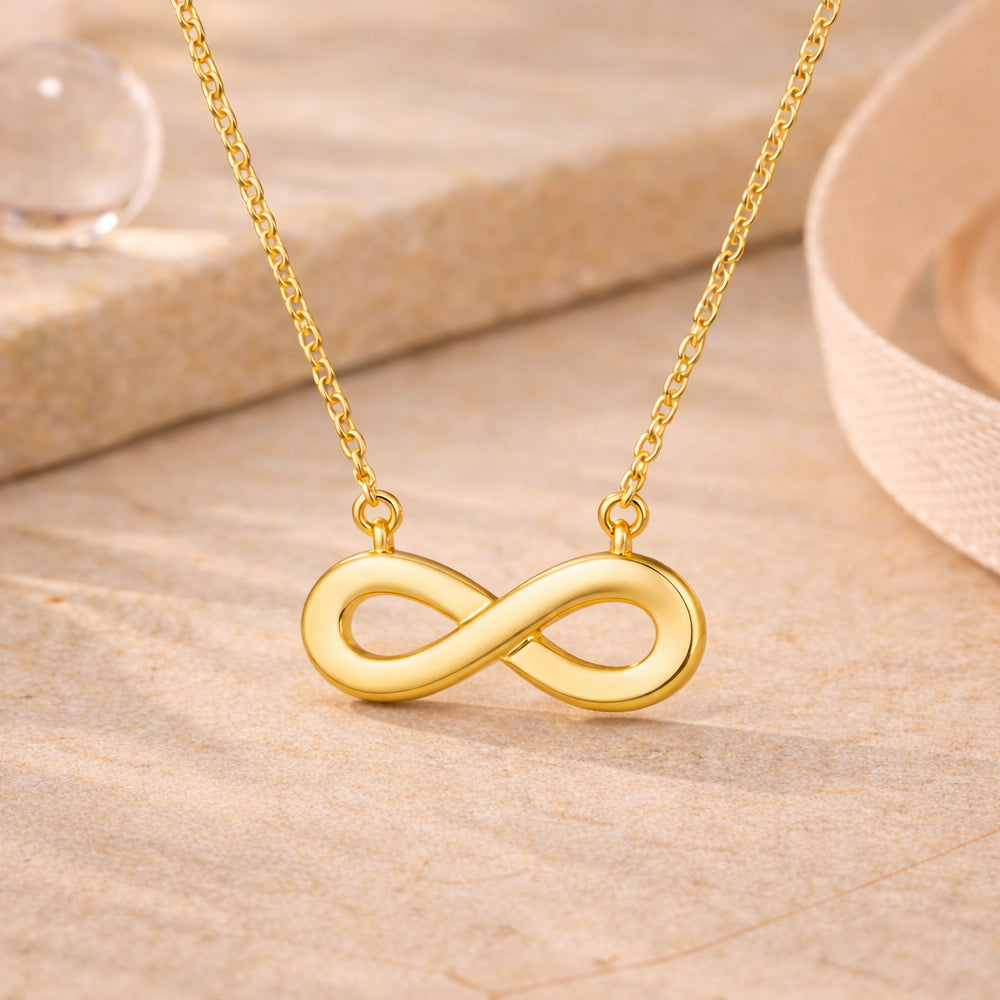 Goldene Halskette mit Unendlichkeitszeichen-Anhänger im minimalistischen Design.
