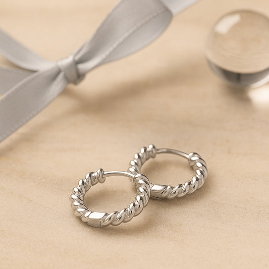 Silberne Creolen mit gedrehtem Design - klassischer, zeitloser Schmuck für Damen.