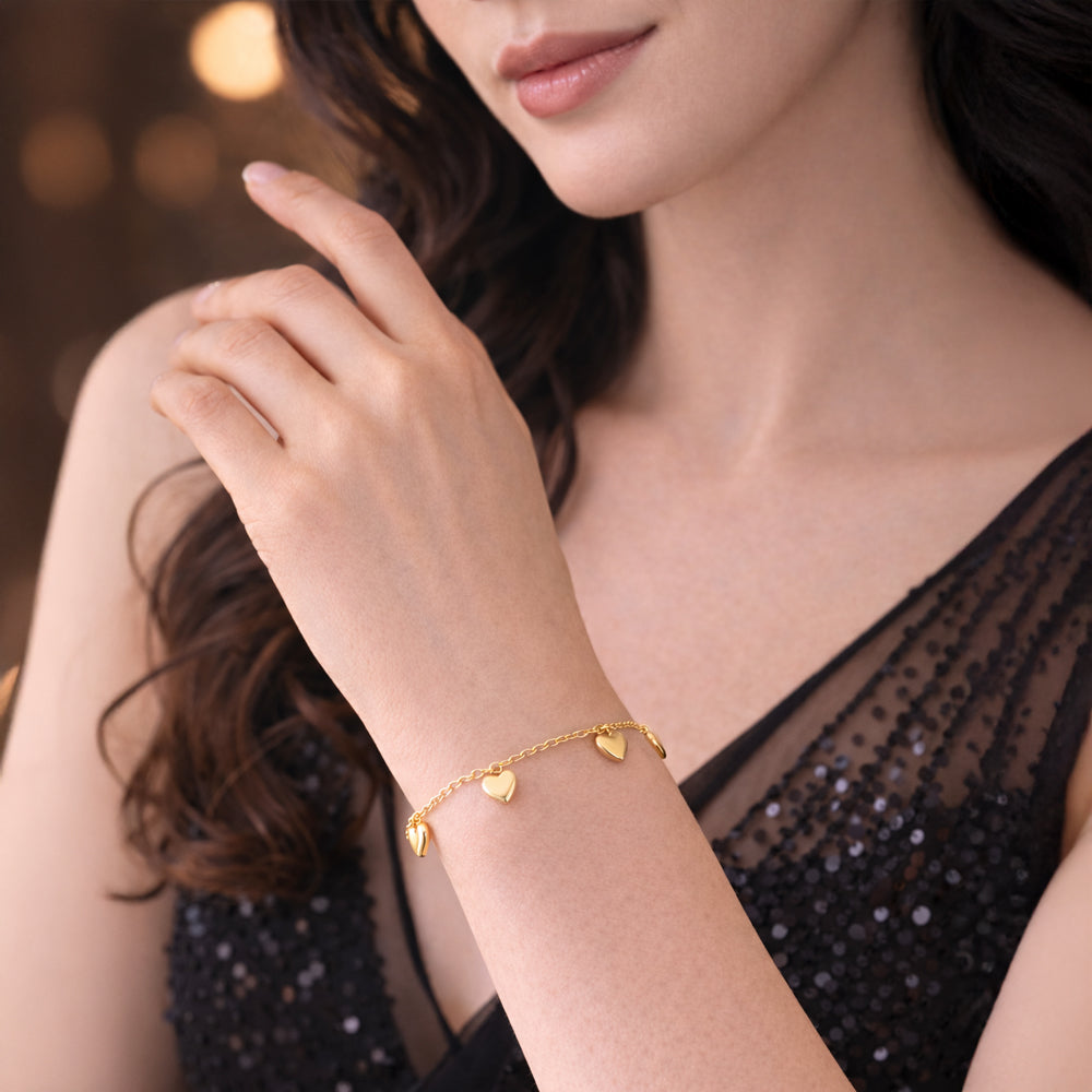 Vergoldetes 925 Sterling Silber Armband mit vier Herzanhängern am Handgelenk getragen