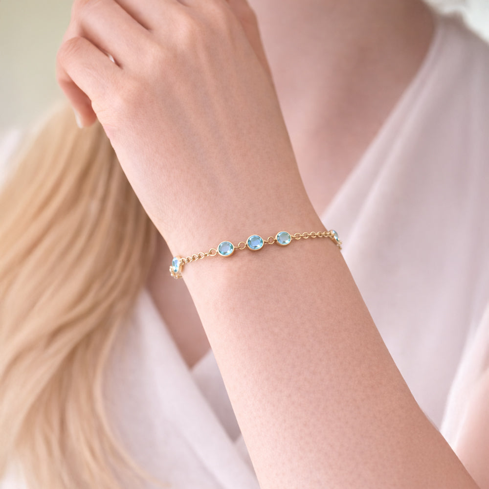 Vergoldetes 925 Sterling Silber Armband mit 9 blauen Zirkonia getragen am Handgelenk