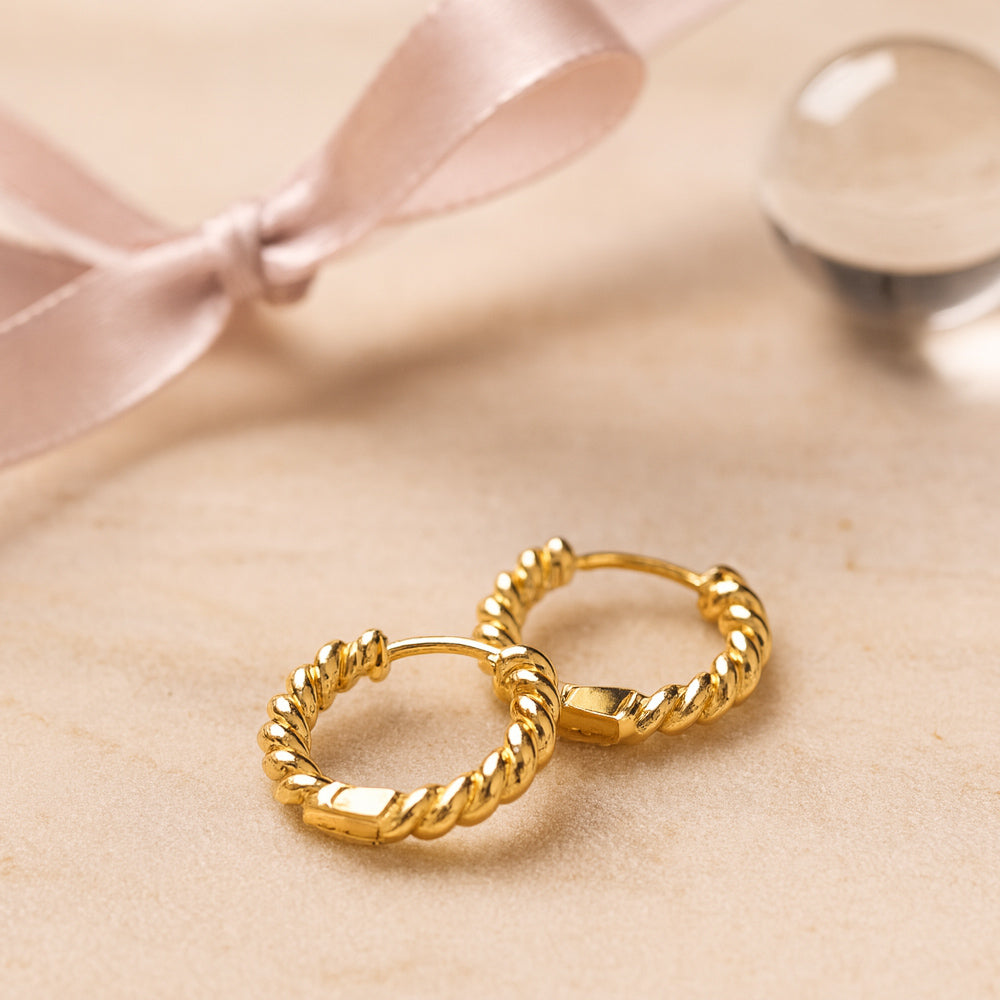 Vergoldete Creolen mit gedrehtem Design - zeitloser, eleganter Schmuck für Damen.